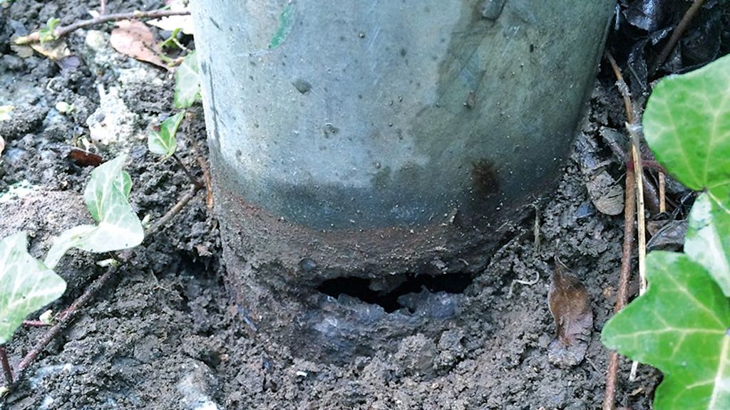 Rost am Metallpfosten im Erdreich.