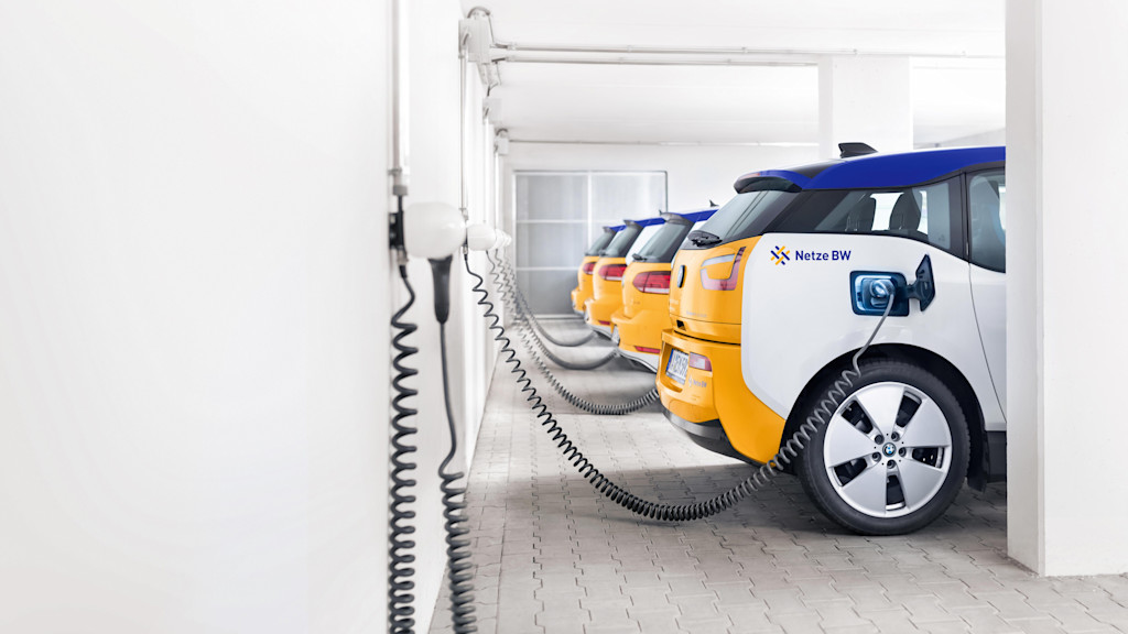 E-Autos stehen an Ladestationen in einer Garage.