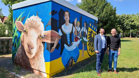 Bürgermeister Jens Hübner von Markgröningen und Kevin Schlund von Netze BW stehen vor der neuen Trafostation