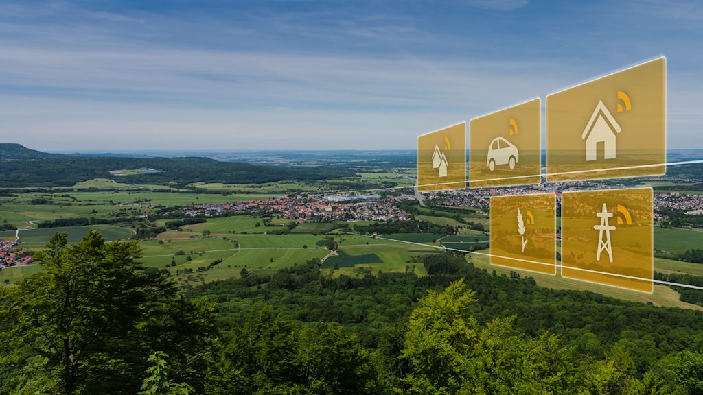 Luftbild von Ort in grüner Landschaft mit Icons von vernetzten Häusern, Autos und Energie.