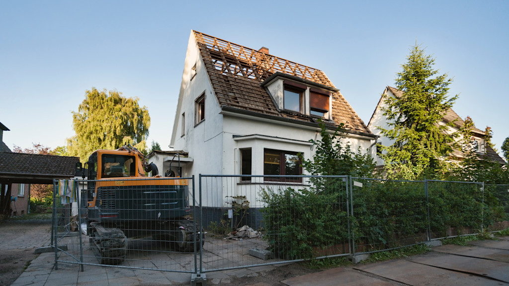 Bagger steht neben einem Haus.