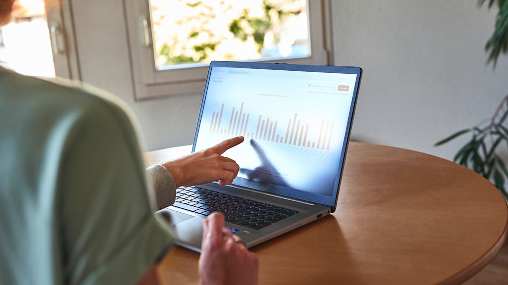 Zwei Personen besprechen ein Diagramm an einem Laptop.