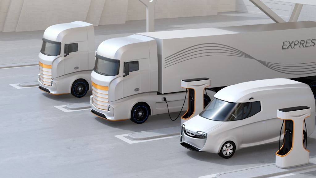 Zwei LKW und ein Transporter laden an Ladesäulen.