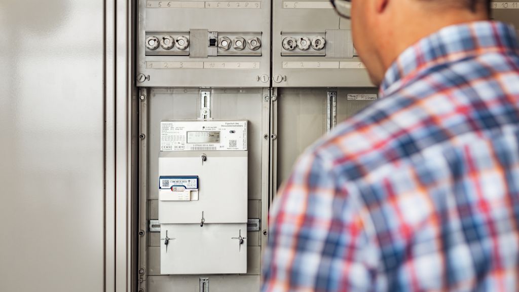 Mann betrachtet ein Smart Meter.