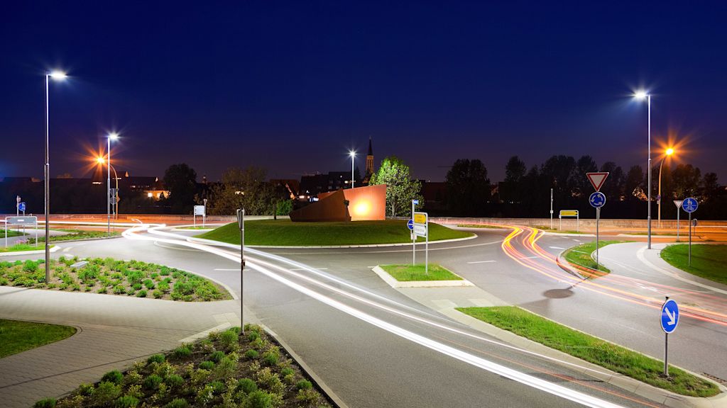 Beleuchteter Kreisverkehr bei Nacht.