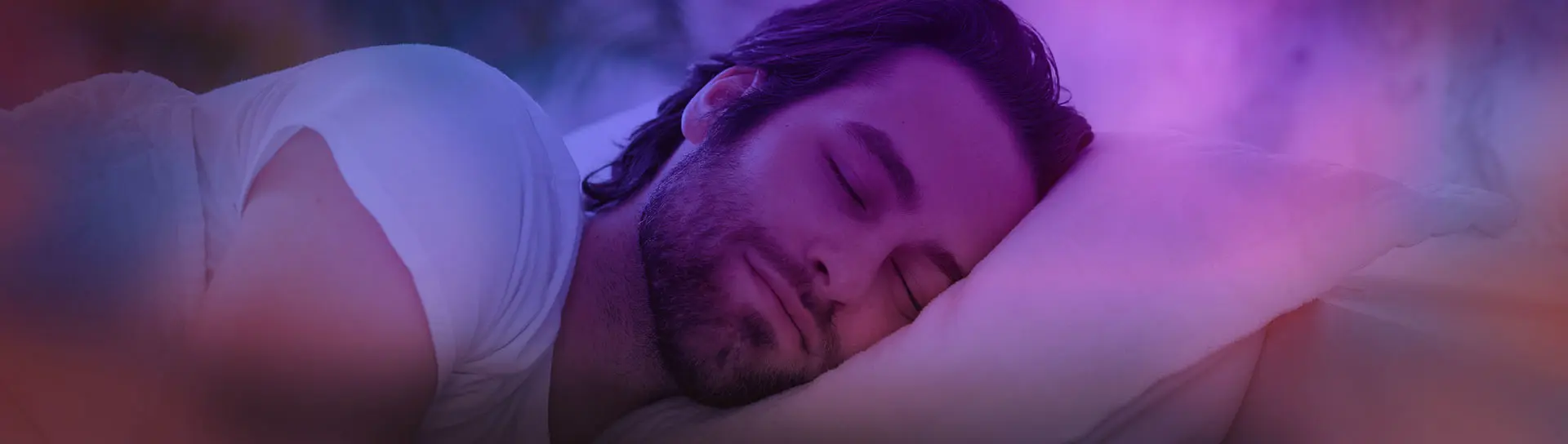 Peaceful bearded young man sleeping in bed alone.