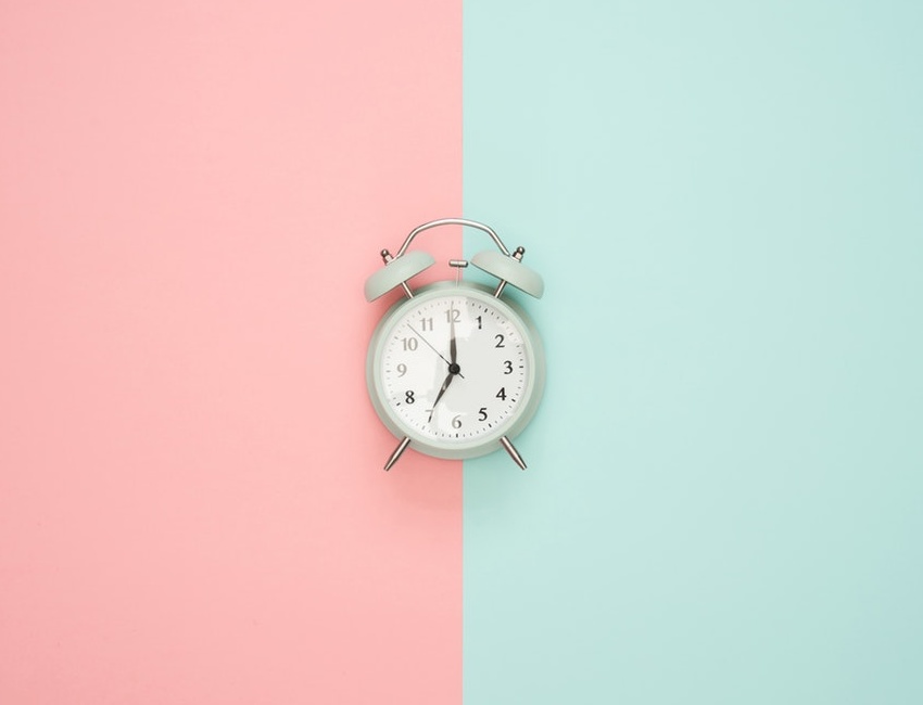 Alarms clock on pink and green background