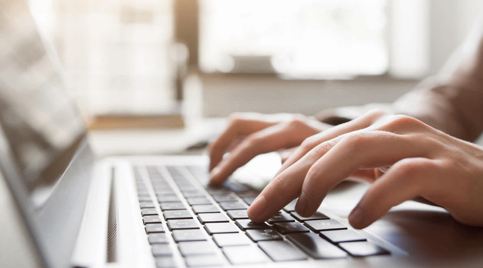 Nahaufnahme Mensch tippt auf Laptop