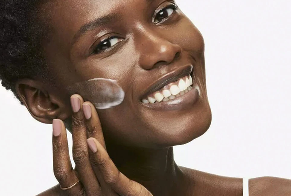 Black woman applying skin cream
