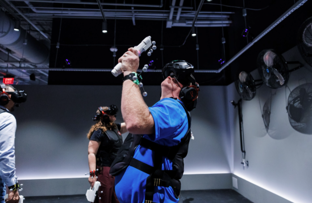 Man looking up while playing a VR experience in full-body motion tracking gear.