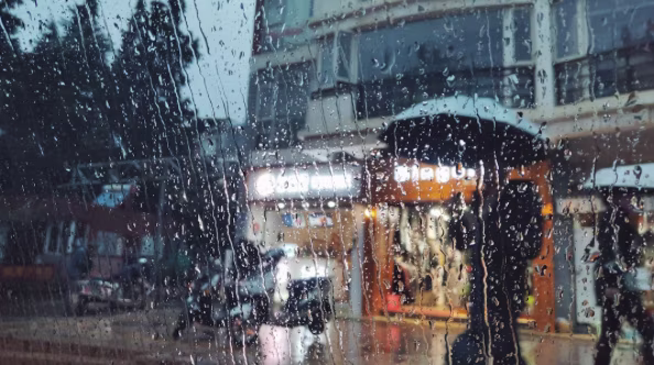 Rainy day as seen through a window, with raindrops on the pane