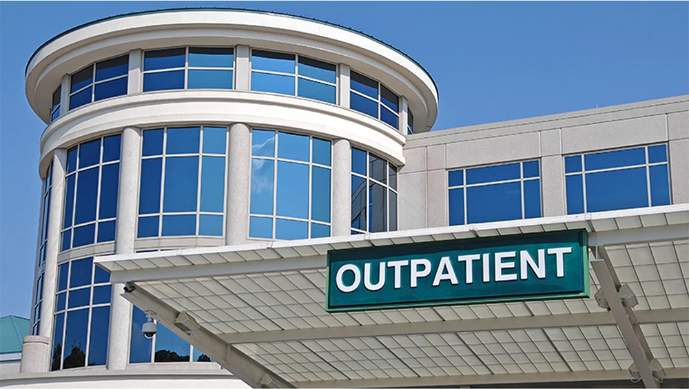 The outside of a hospital building with a sign that says "Outpatient"