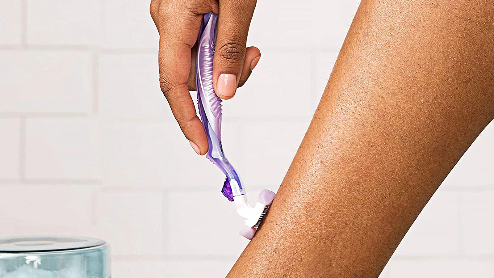 Femme se rasant la jambe sur une peau sèche