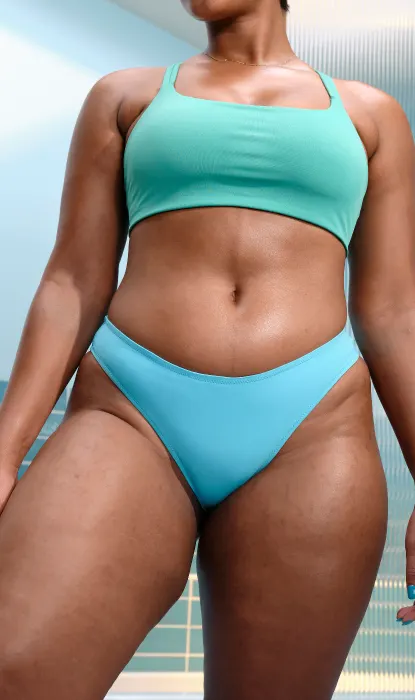 Une femme en bikini bleu sous un ciel clair