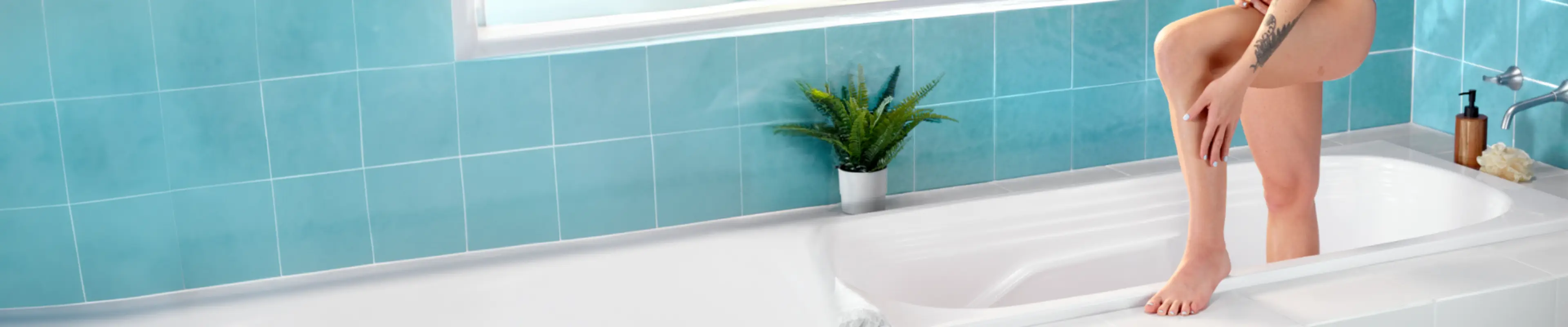 Femme se rasant les aisselles dans la salle de bain, démontrant une technique de rasage appropriée et des soins de la peau dans un environnement lumineux.