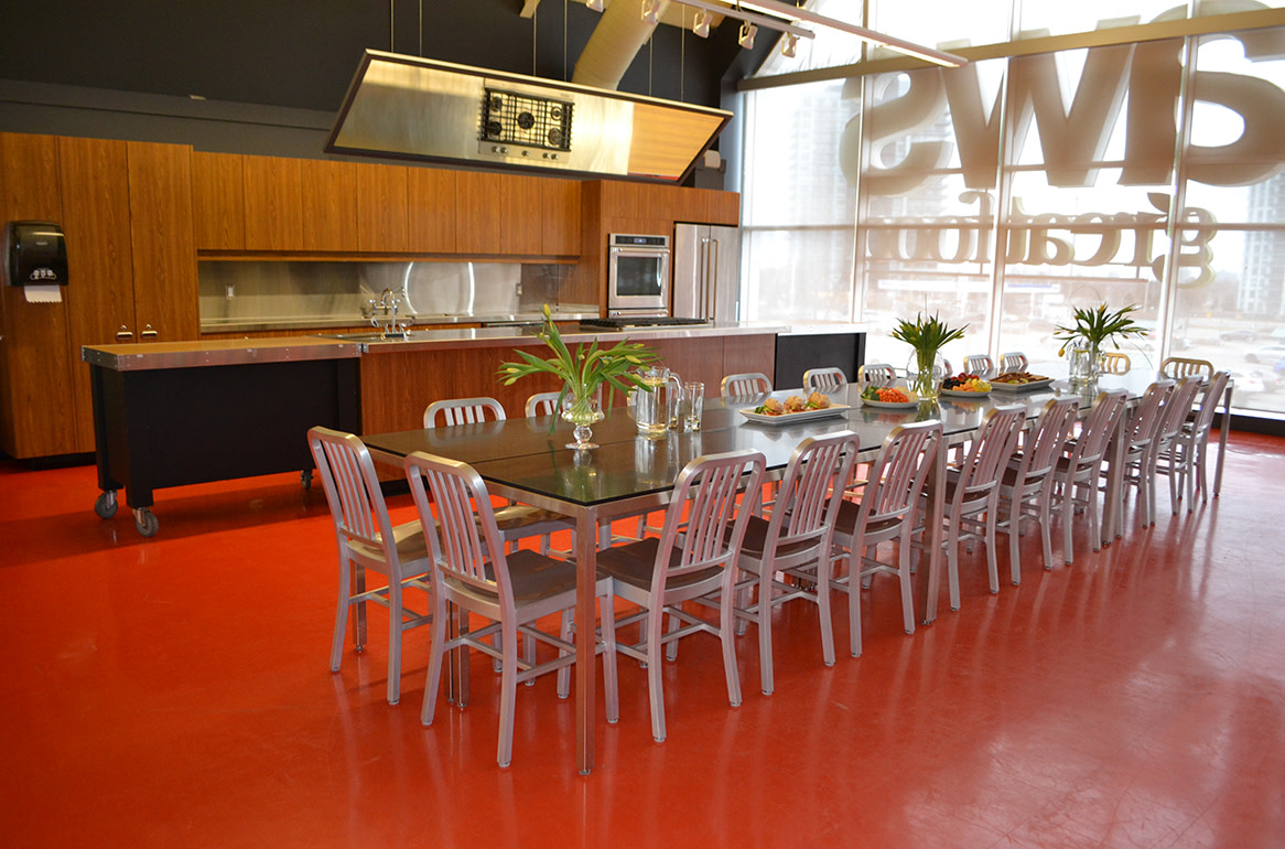Une image de la cuisine d'une école culinaire avec une table décorée et des chaises.