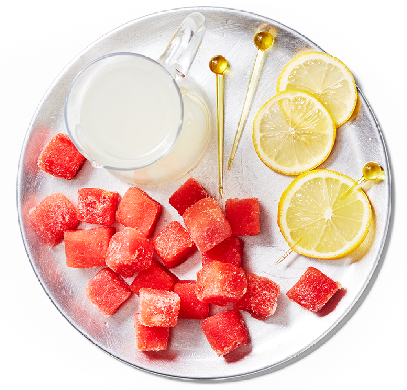 Plate filled with PC Frozen Watermelon Chunks and lemon slices and a glass of lemonade