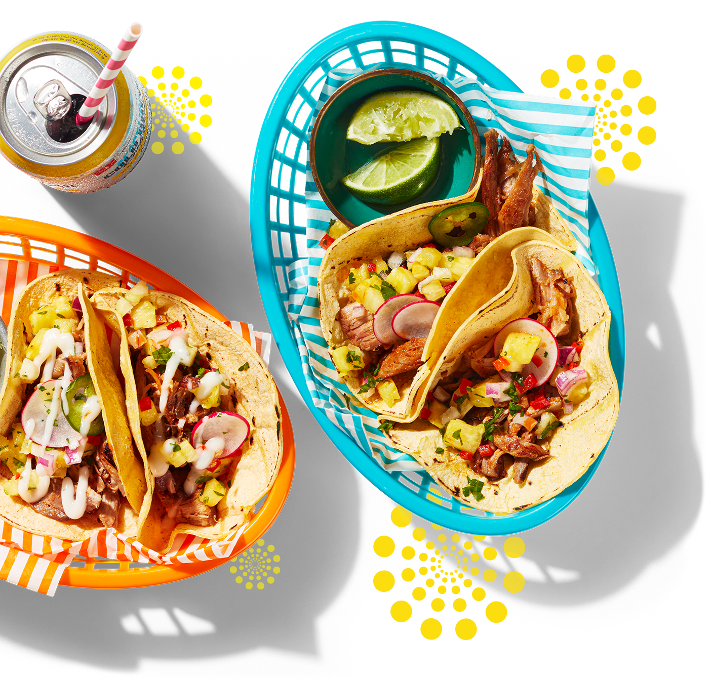 Deux paniers remplis de tacos de homard tout garnis avec des quartiers de lime et une boisson gazeuse.