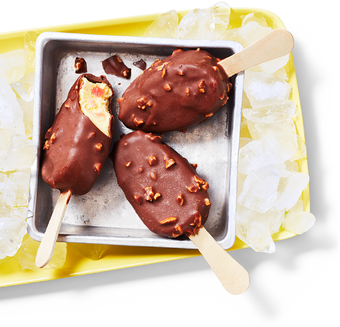 Des Mini barres de crème glacée à la banane royale PC Bar laitier dont une barre a été croquée sur une plaque de cuisson carrée