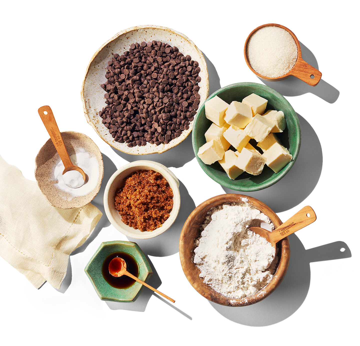 Plusieurs bols d'ingrédients déjà préparés et mesurés, dont du beurre à base de plantes et des brisures de chocolat.