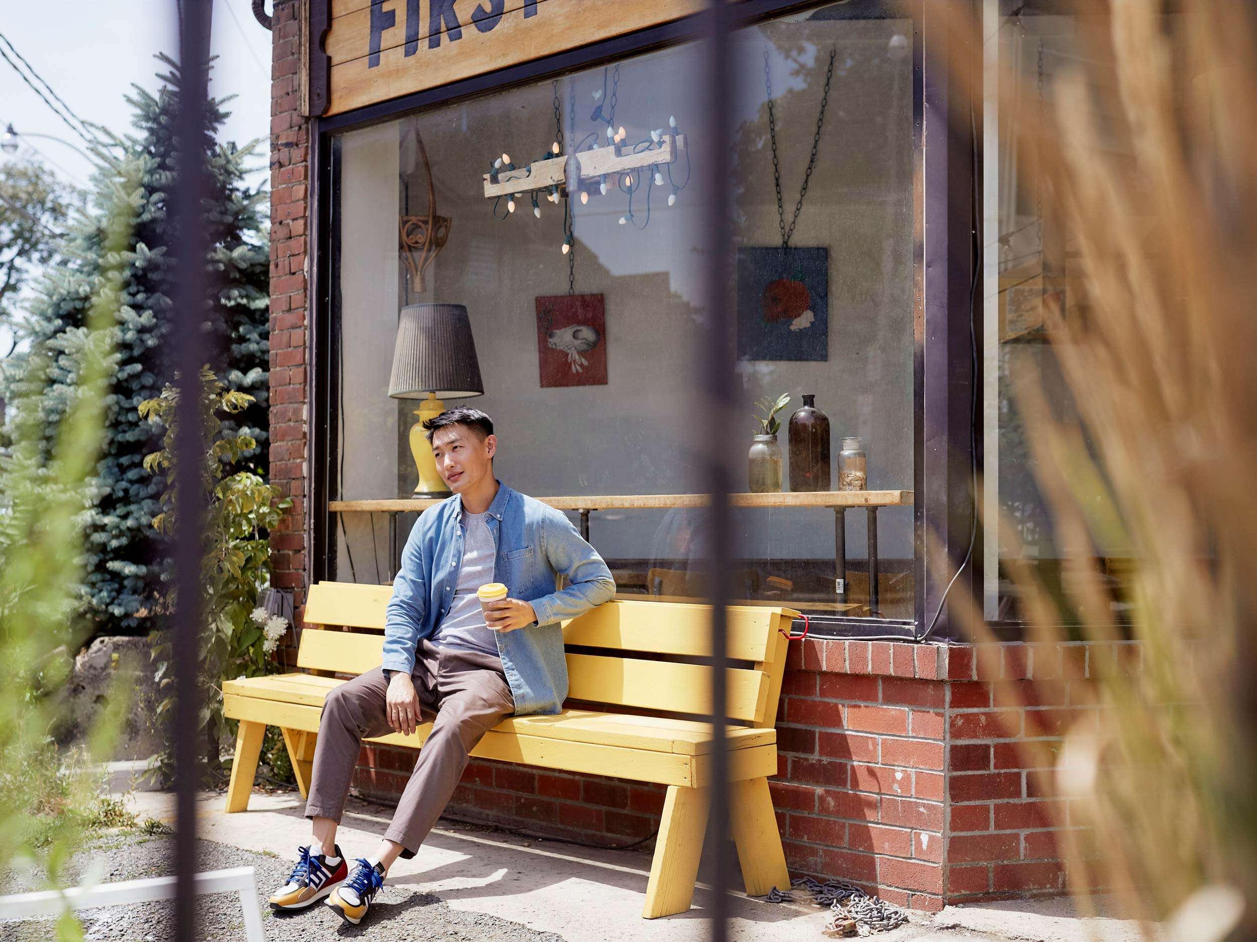 Man sitting on bench outside of cafe