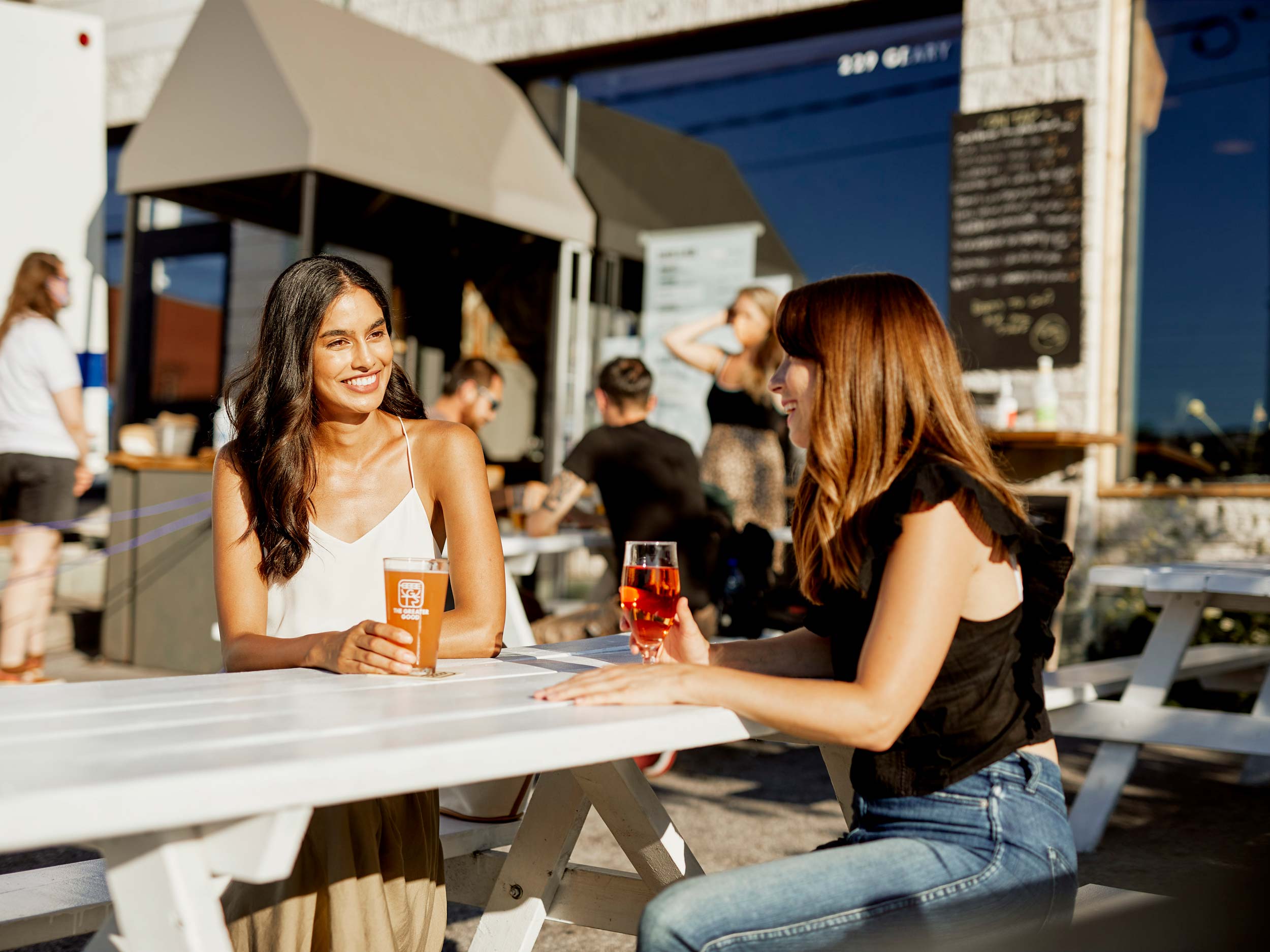 Two women sitting at a brewery patio