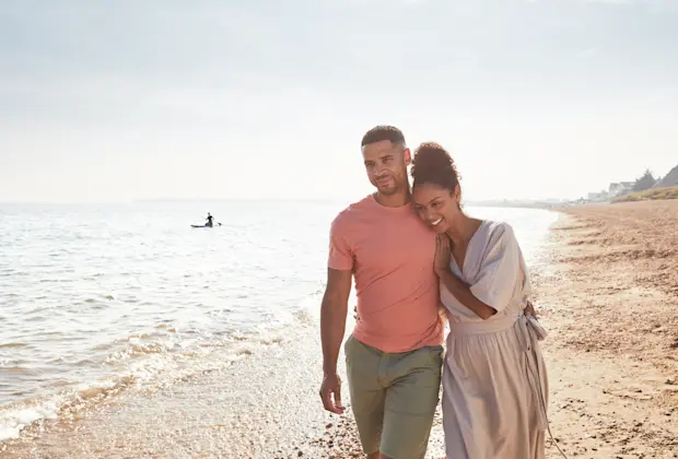 Couple walking along the beach at Weymouth Bay