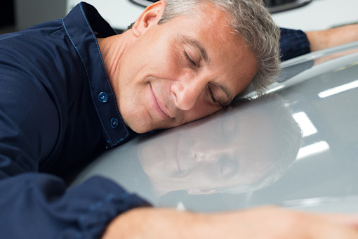 Man hugging bonnet of car