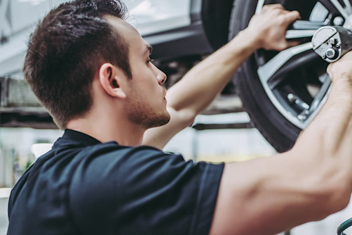 Mechanic fitting car with new tyres