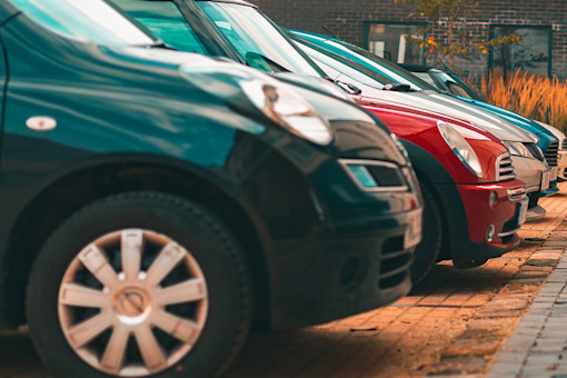 A row of cars parked outside an apartment block