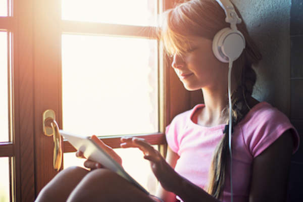 Teen listening to music on tablet