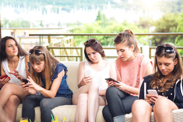 Teens on phones ignoring each other