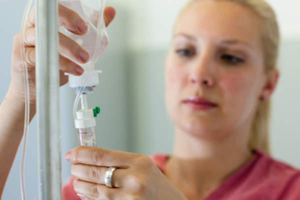 Nurse adjusting drip of infusion