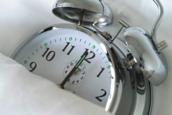 Insomnia concept, alarm in bed