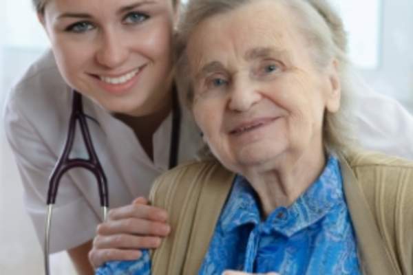 Nurse and elderly woman in nursing home.