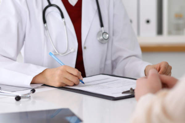 Doctor talking with patient while taking notes