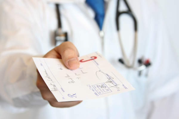 Doctor handing a prescription over.