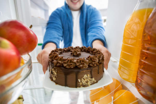 Healthy fridge but chocolate cake being taken out