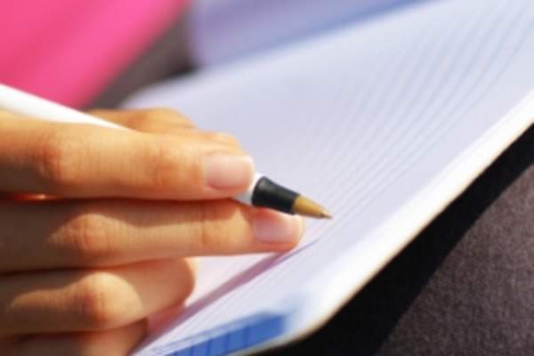 Woman writing in journal.