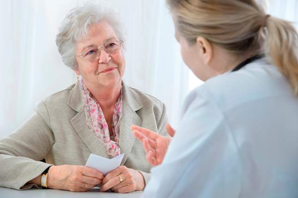 Senior woman getting a prescription from her doctor.