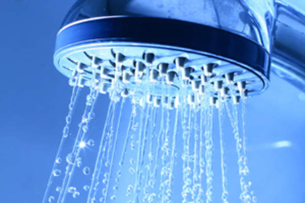 Shower head close up, water running.