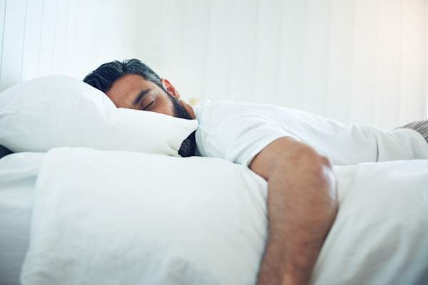 Man sleeping soundly on bed.
