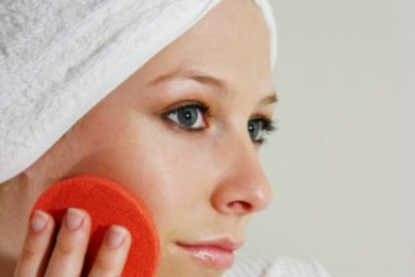 Woman keeping her skin looking good using exfoliating pad.