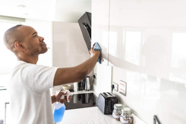Father cleaning kitchen cabinets.