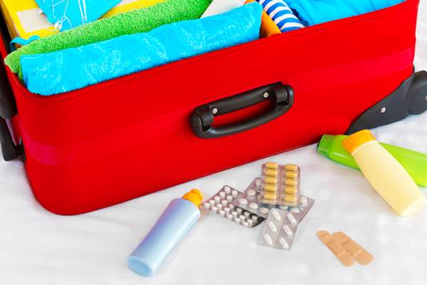 Medications in front of suitcase.