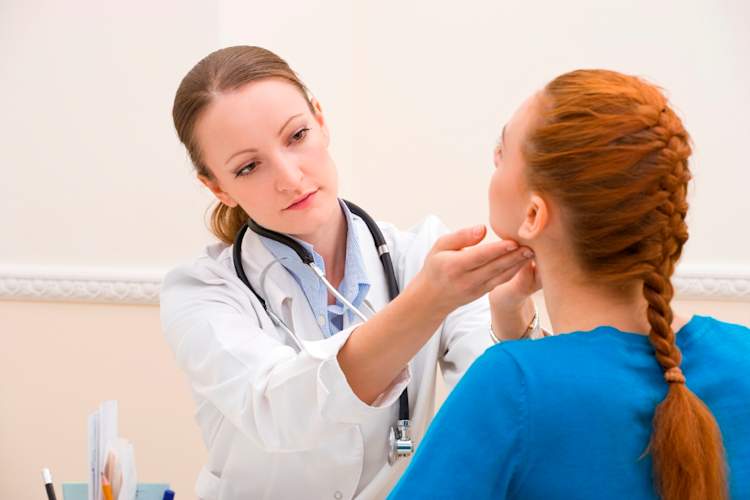 A doctor gives a young woman a checkup.