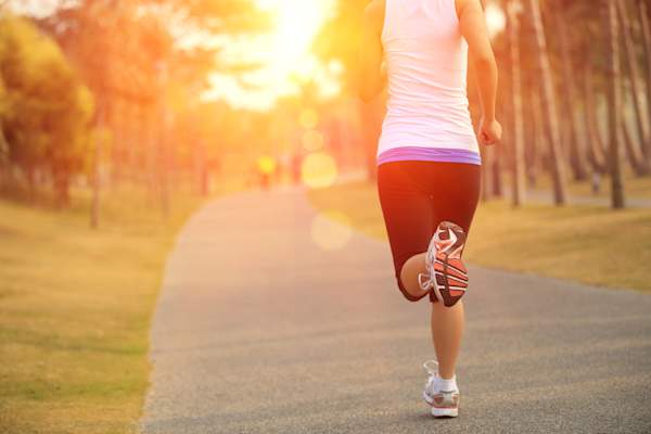 Woman jogging on park path.