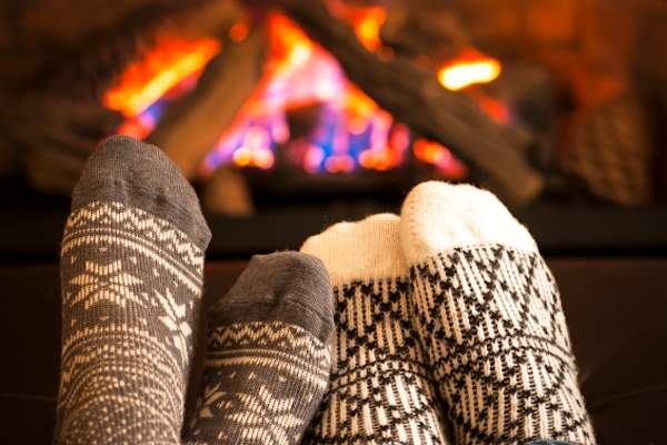 Comfy socks near a fireplace.