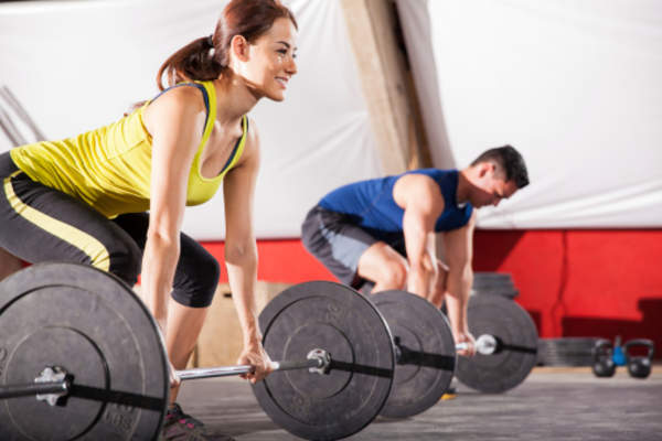 Man and woman lifting at the gym.