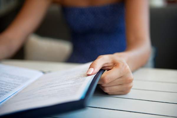 Woman reading a menu at a restaurant.